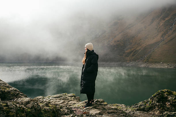 istock Young woman by a lake in winter 2248182571