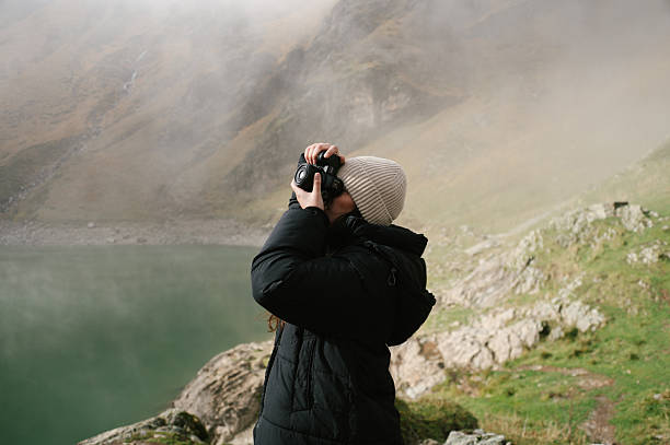 istock Young woman taking a picture with a camera 2248182685