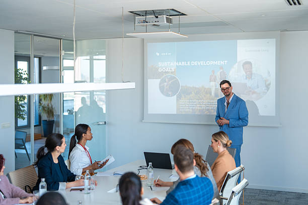 istock Confident Businessman Leading Presentation in Modern Boardroom with Diverse Team 2248182889