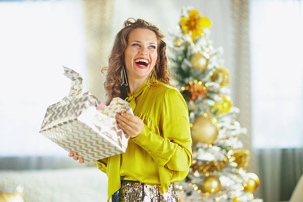 istock Smiling Woman with Partially Opened Christmas Gift 2248185126