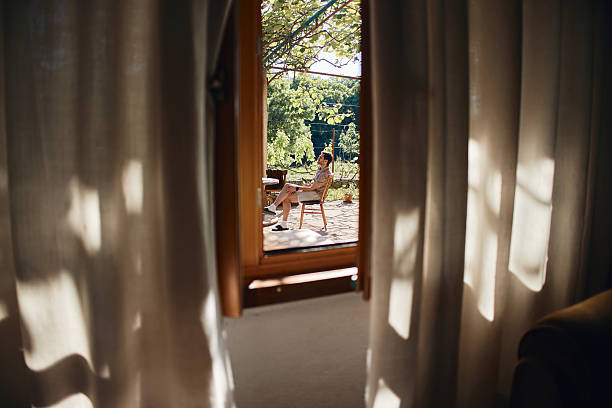 Man enjoying solitude on an outdoor terrace looking at lush green garden on a summer day