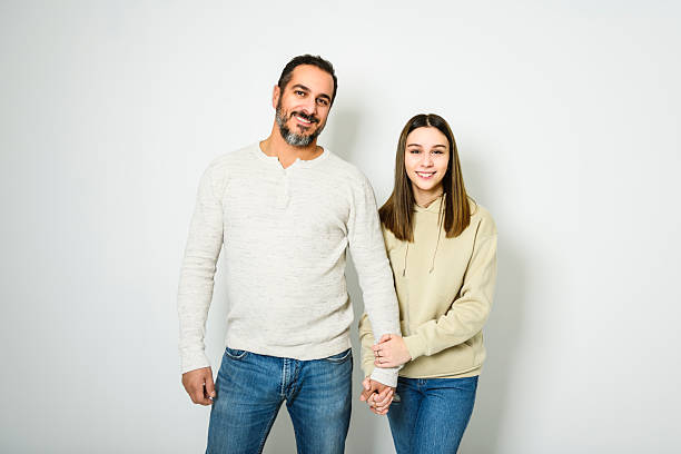 istock father and cute teen isolated on white on studio 2248188841