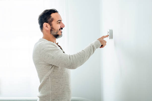 istock nice man set the thermostat at house 2248188847