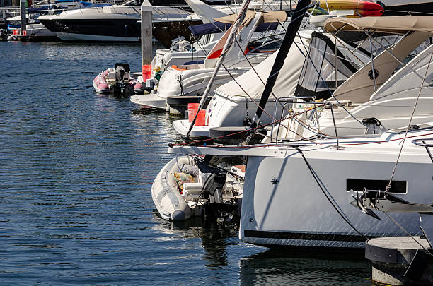 Boats and floating docks reflected in calm marina water under bright sunlight and peaceful coastal ambiance.