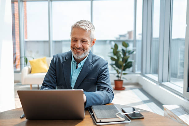 istock Professional businessman working on a laptop in a bright modern office setting 2248190394
