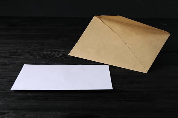 istock Kraft paper envelope with letter on black wooden table. Mockup for design 2248191483