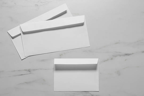 istock Paper envelopes on white marble background, flat lay. Mockup for design 2248191541