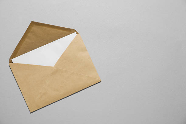 istock Kraft paper envelope with letter on gray background, top view. Mockup for design 2248191572