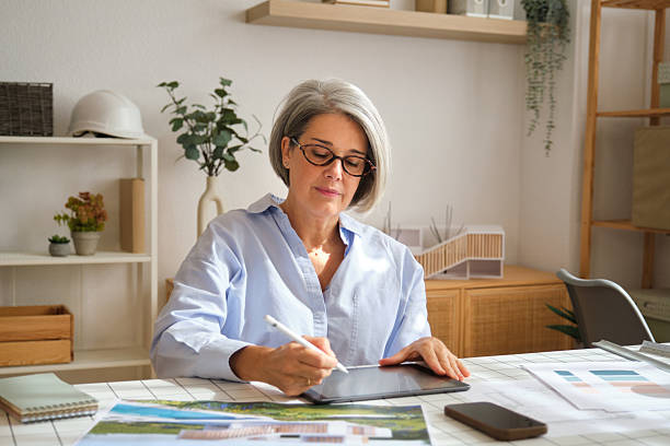 istock Senior female architect working on digital tablet at office 2248194088