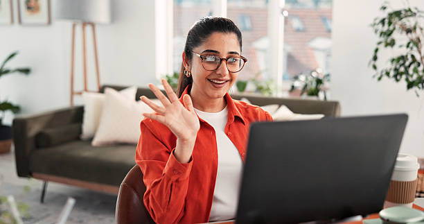 istock Woman, wave and video call in home with laptop for remote work, virtual conference and discussion. Freelancer, person and greeting with computer for online meeting, webinar communication and welcome. 2248196621