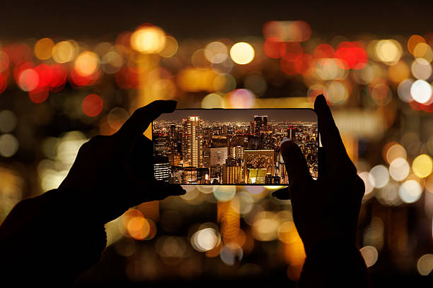 istock Smartphone framing illuminated night cityscape with bokeh lights 2248197499