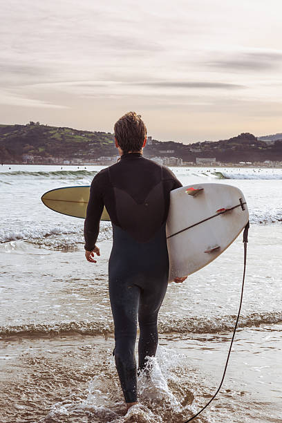 istock Surfer Walking Into the Ocean at Sunrise 2248198348