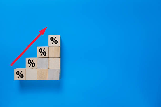 istock stack wooden blocks with rising percentage rate isolated on blue background. concept of business growth or increasing interest rate 2248199991
