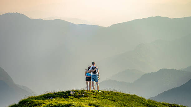 istock Hikers on a Grassy Hilltop Overlooking a Misty Mountain Range 2248200328