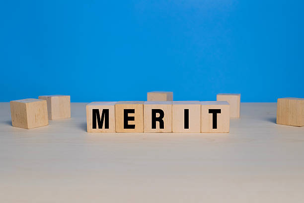 istock merit word text on wooden blocks isolated on blue background 2248200557
