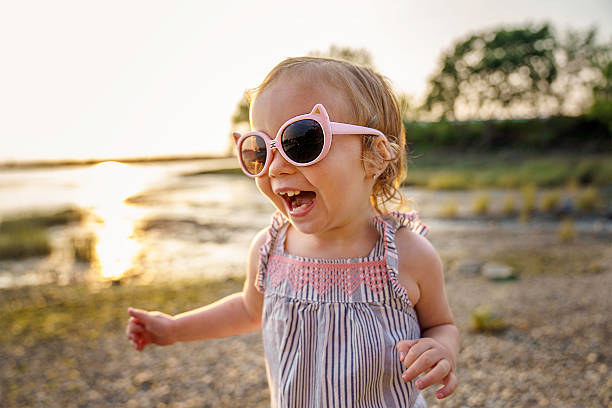 istock Baby outdoors enjoying nature on the sunset beach with sunglasses 2248202149