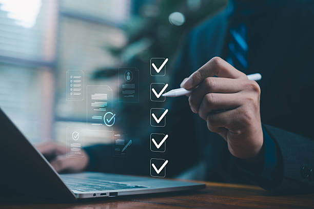 istock Businessman marking digital checkboxes on a laptop, showing task management, checklist review, verification process, modern digital workspace. check of document, list survey, form business 2248205302