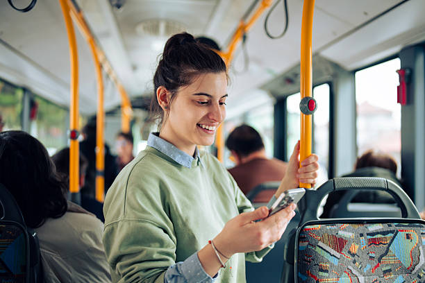 istock Young woman using smartphone while standing in public transport. 2248206432