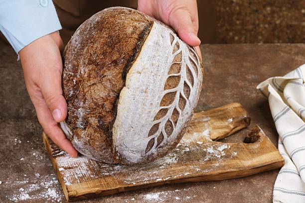 istock Chef Holding Artisan Scored Sourdough Bread 2248207290