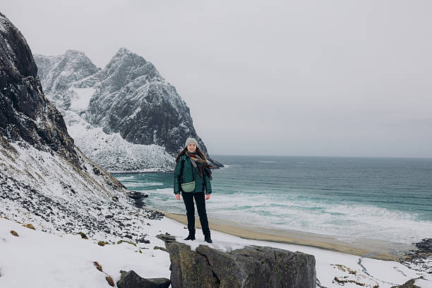 istock Cheerful Female With Backpack Admiring Dramatic Winter Mountain Beach From Above on Lofoten Islands 2248208258