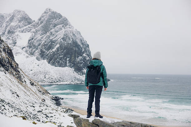 istock Female With Backpack Admiring Dramatic Winter Mountain Beach From Above 2248208382