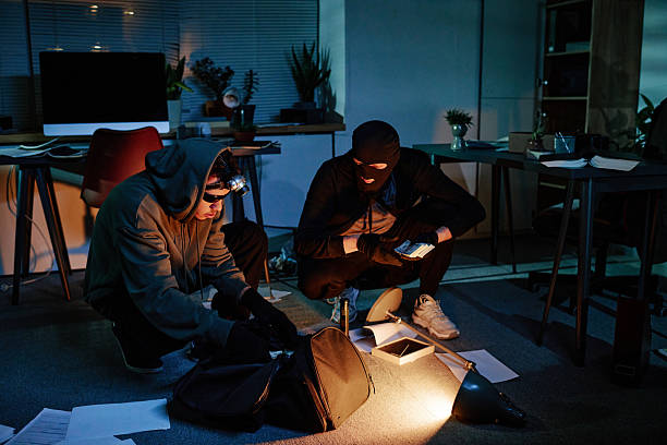 istock Two Young Adult Men Stealing Documents and Electronics in Dark Office at Night 2248211484