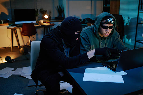 istock Two Young Adult Men Stealing Data from Laptop in Office at Night 2248211516
