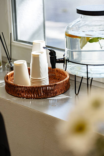 istock Empty white cups and water dispenser in a cozy cafe setting during the day 2248211705