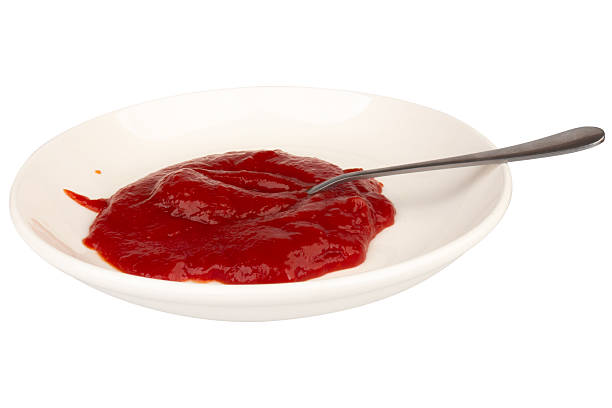 istock Ketchup splashing on a white plate spoon on white background 2248212614