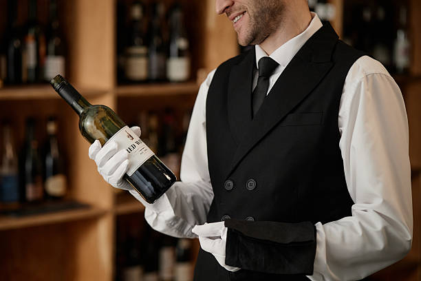 istock Young Caucasian Man in Uniform Evaluating Wine Bottle during Tasting Session 2248214070