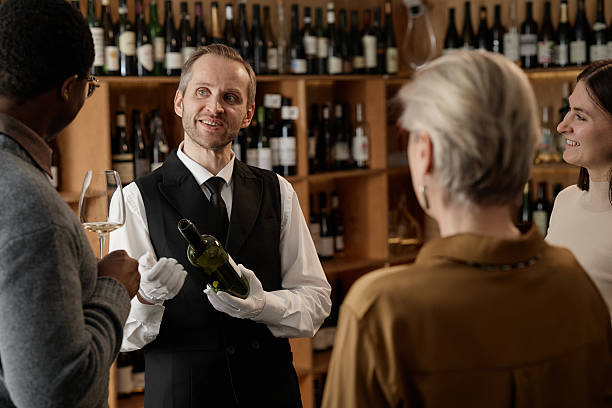 istock Caucasian Middle Aged Man Presenting Wine Bottle to Diverse Adults Tasting Wine 2248214137