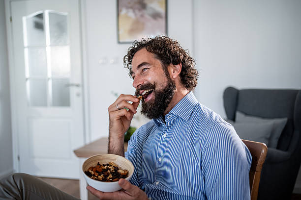 istock Happy man laughing while eating healthy snack 2248216539