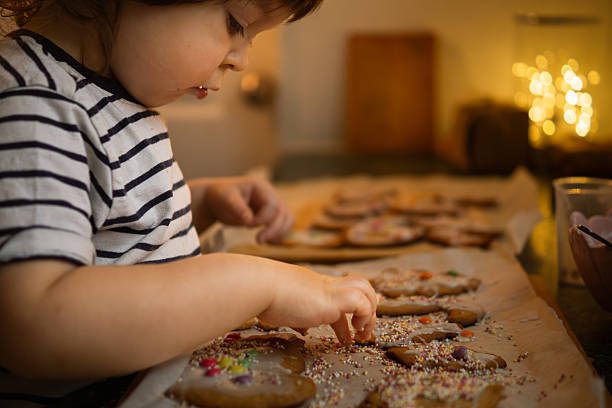 istock Young Child Decorating Gingerbread Cookies with Sprinkles 2248216932