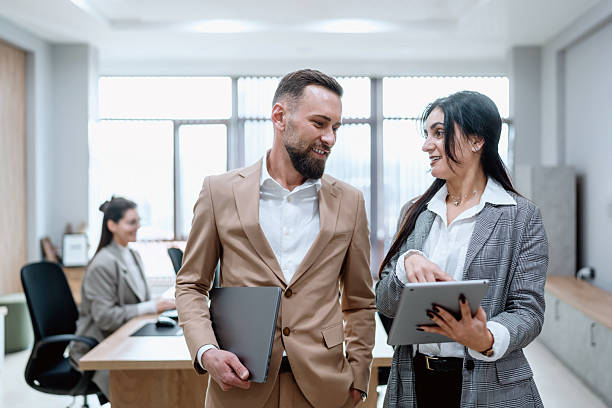 istock Two business colleagues discussing work in modern office environment 2248217259