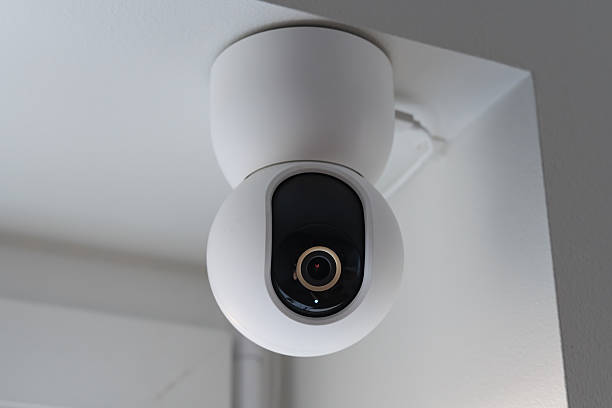 istock Modern white indoor security camera mounted on the ceiling for smart home surveillance system and property safety protection. 2248218265