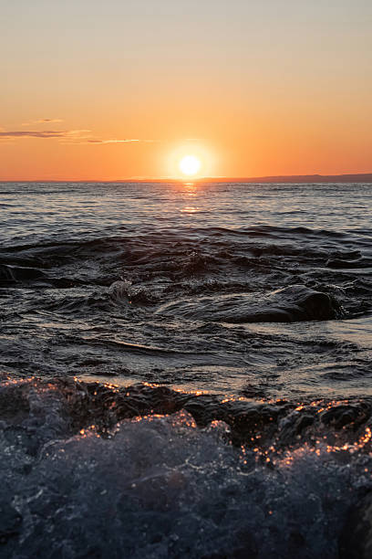 istock Sunset sun at the horizon, dark water 2248218508