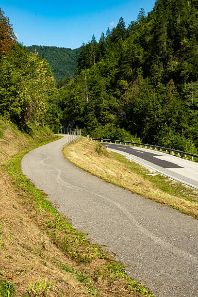 istock Cycle Path and Scenic Road in the Alps Surrounded by Mountain Landscape 2248220881