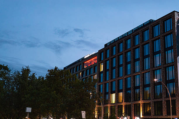 Berlin, Germany – October 22, 2025: The AMANO East Side hotel building is illuminated at dusk, with windows glowing against the evening sky.