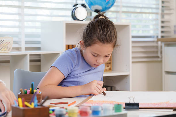 istock Caucasian elementary girl student carefully drawing with crayons at classroom desk representing creativity imagination dedication artistic expression educational growth childhood positive learning 2248222458