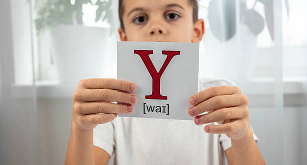 istock Boy presenting a flashcard with the letter Y and its phonetic transcription for studying 2248228261