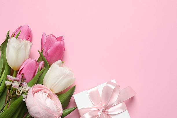 istock Beautiful bouquet and gift box on pink surface 2248229568