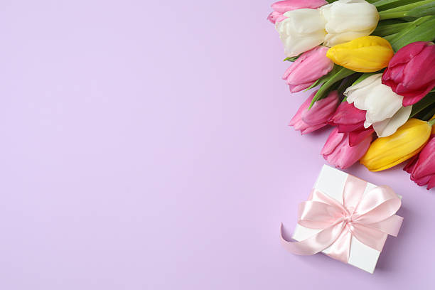 istock Top view of gift box and tulips on color surface 2248229620