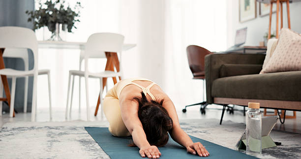 istock Yoga, home workout and woman stretching with tablet, warm up routine and online tutorial. Digital class, live session or person streaming fitness video in lounge, exercise mat or follow steps 2248232021