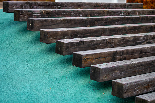 Wooden beams installed on green surface forming terrain steps within a modern residential playground area landscape design