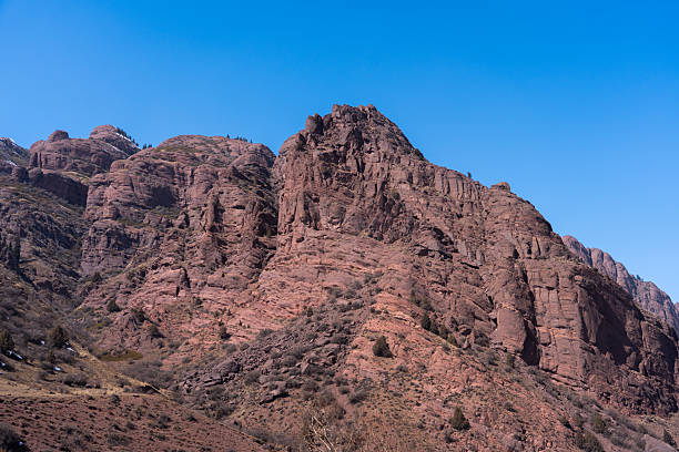 istock Towering rocky red mountain peak against a clear blue sky 2248238865