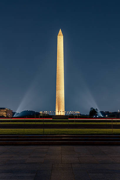 istock Washington Monument illuminated at night with flags and light beams. 2248239364