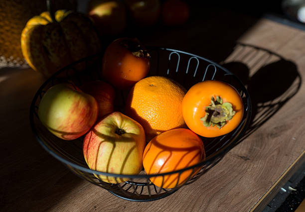 istock Fruit bowl with apples and persimmons in sunlight 2248239410