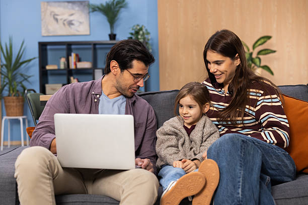 istock Family watching laptop together on sofa at home 2248240203