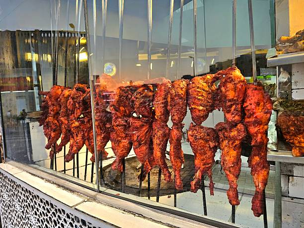 spit with roast chickens and pork knuckle while cooking in the restaurant specializing in meat dishes