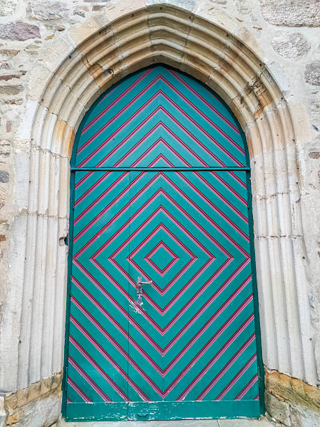 Old wooden church door with colourful paint in turquoise and magenta